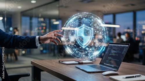 Professional businessman interacting with a holographic shield icon for cybersecurity protection using advanced digital software on a modern wooden desk