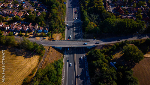 Aerial view of the M27 motorway and Nursling Substation, featuring multi-lane traffic, surrounding residential areas, and green fields in Southampton, England, United Kingdom.