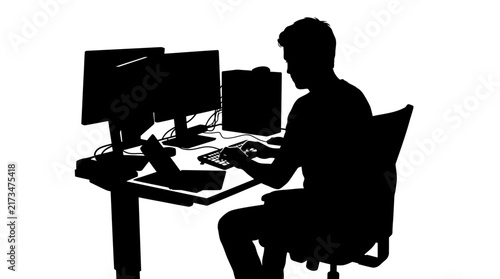 Silhouette of focused male programmer typing on keyboard while sitting at his desk using multiple monitors