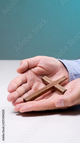 Bild auf Leinwand Person's cupped hands gently holding a small wooden cross, representing concepts