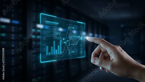 Hand touching a glowing digital interface with data charts in a dark server room environment