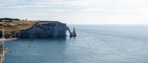 Vista panorámica de los acantilados de la costa de Etretat en la Normandía de Francia, con un arco de piedra y una roca puntiaguda al lado sobre un mar azul viajando en un dia de verano 2022