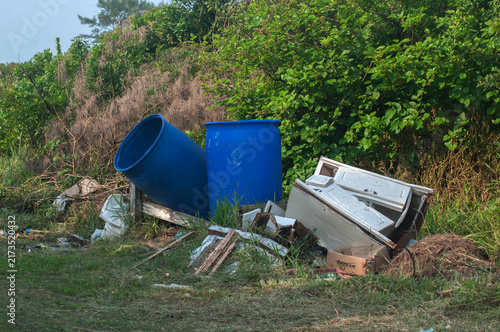 Two large trash blue barrels on a wooden pallet in the street 