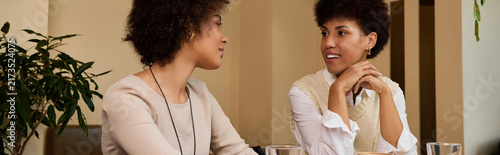 Foto Two stunning young African American women share laughter and stories, creating cherished memories