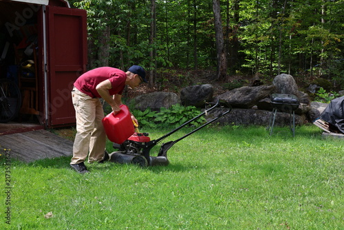 Fotografía man filling lawn mower with gas