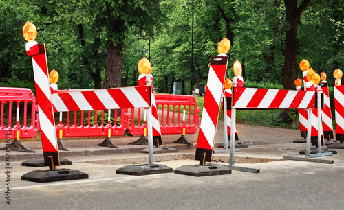 Foto Red and white warning barricade at a road construction excavation
