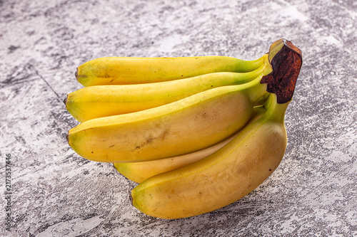 Fresh yellow bananas on textured gray surface