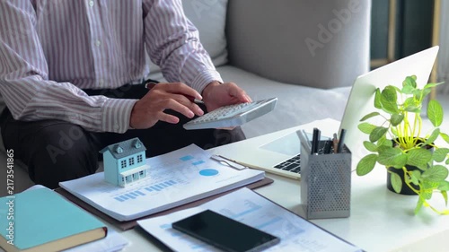 Accountant calculating property taxes and mortgage payments at home office.