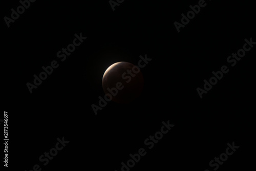 Cuadro en lienzo Blood moon appearing in the dark night sky during a total lunar eclipse, symboli