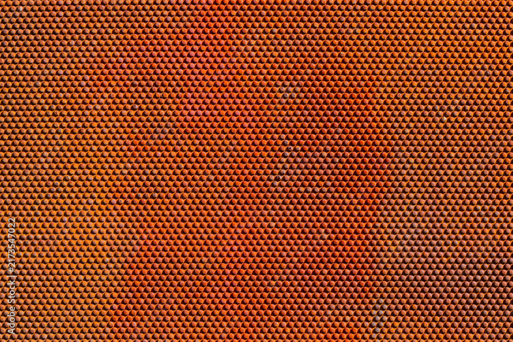 Obraz premium Close-Up of Orange-Red Textured Surface with Hexagonal Pattern