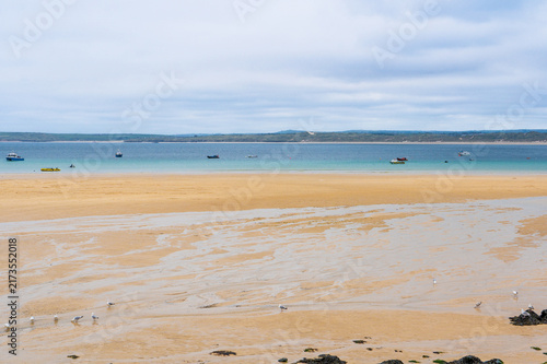 Bild auf Leinwand Sandy beach at low tide with turquoise water on an overcast day.