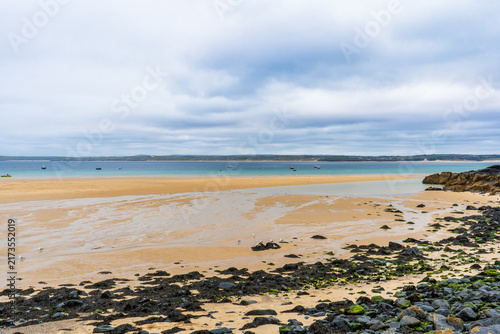 Foto Sandy beach at low tide with turquoise water on an overcast day.