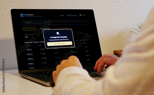 Foto Educator at a laptop using AI software for automated bulk grading of student ess