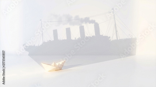 Small origami paper boat casting large shadow of steamship representing hidden potential