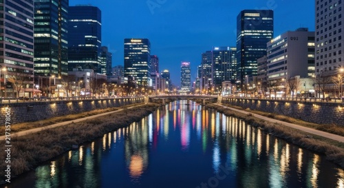 Cityscape at dusk skyscrapers line a waterway, reflected lights create a vibrant scene
