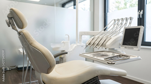 Bright modern dental office interior with white chair and instruments