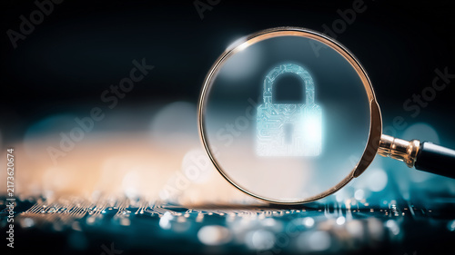 A magnifying glass focused on a digital padlock represents cyber security risk assessment and protection of sensitive data.
