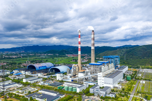 Aerial view of large thermal power plant with cooling towers under cloudy sky