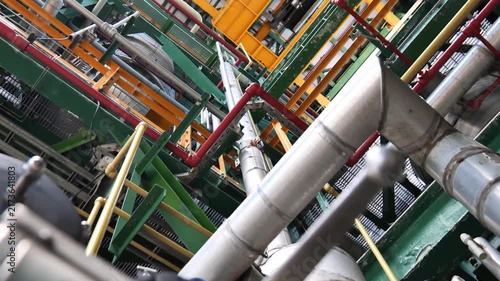 Interior view of a sophisticated oil and chemical processing facility with industrial pipes, control valves, machinery, and engineering equipment, illustrating complex manufacturing processes and mode