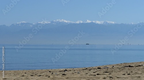 富山湾の砂浜から望む冠雪した立山連峰と青空