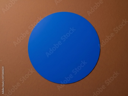Minimalist blue circle centered on a brown paper background