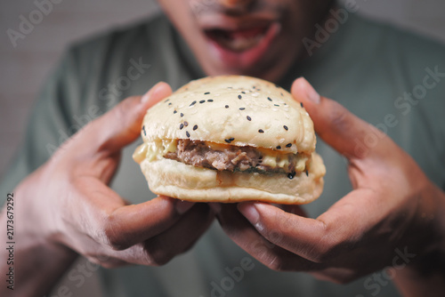 Фотография Enjoying a burger with sesame seeds in hands
