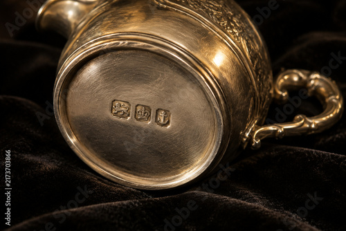 Antique silver cream jug with hallmark stamps on dark velvet, craftsmanship and heritage concept