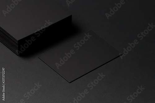 Stacked and single matte black cards on a dark, textured surface