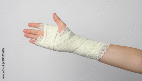 Close up on hand wrapped with bandage on a gray background