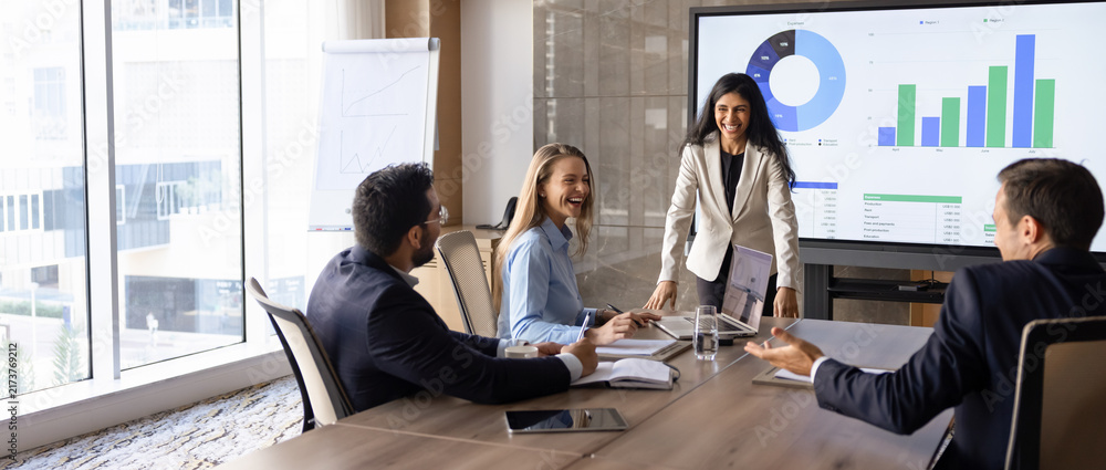 Obraz premium Colleagues discussing charts displayed on screen during positive project review, corporate reporting meeting within team members. business collaboration, financial analysis, strategic planning, banner