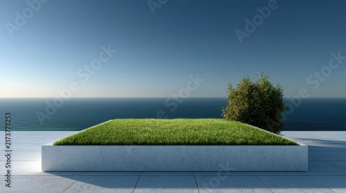 Minimalist concrete platform with grass and tree overlooking calm ocean and clear blue sky lawn