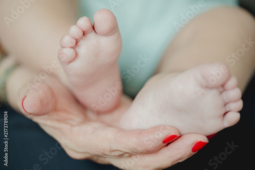 Fotografie Tender close-up of a baby's small foot with tiny toes resting against a soft blue background