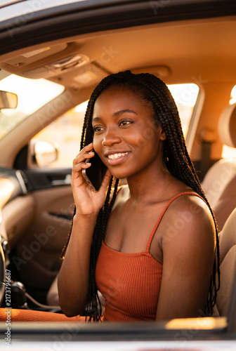 Young African American woman talking on phone in car