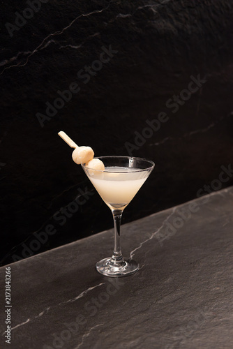 Elegant Martini Cocktail with Onion Garnish on Dark Surface.