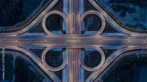 Aerial top view of cloverleaf highway interchange with night traffic light trails