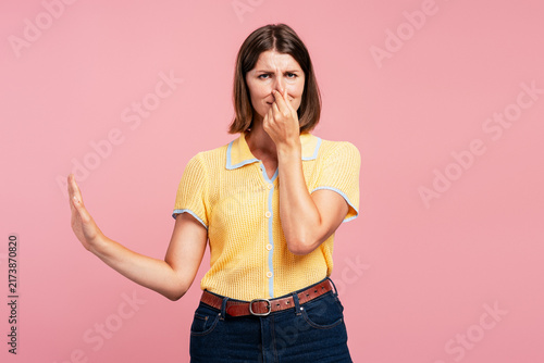 Foto Woman pinching nose stopping bad smell gesture