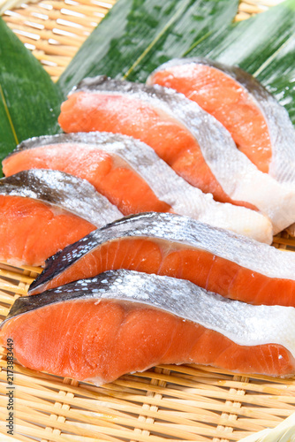 Bild auf Leinwand Fresh salmon fillets with silvery skin arranged on a bamboo mat, showcasing the