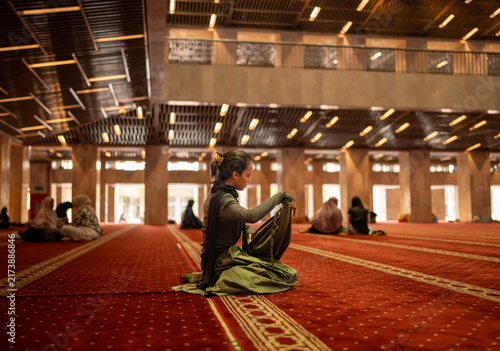фотографія Muslim woman preparing for prayer in mosque