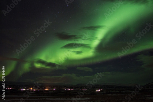 Aurora Borealis. Iceland near Myvatn lake in winter. Beautiful dancing northern lights over winter mountain landscape