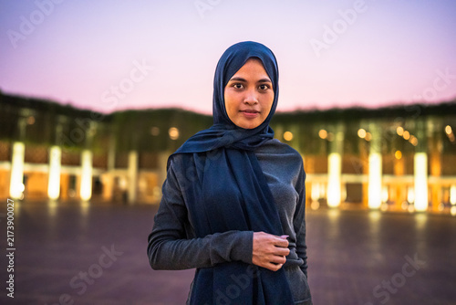 Fotografie Muslim woman wearing hijab standing outdoors at dusk
