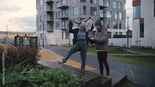 Friends talk and enjoy time outside at a playground in the city during the evening
