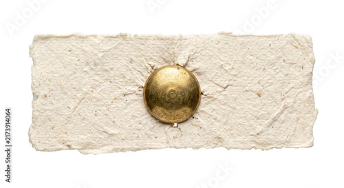 Fotografie Close-up of a golden tack securing rough textured handmade paper