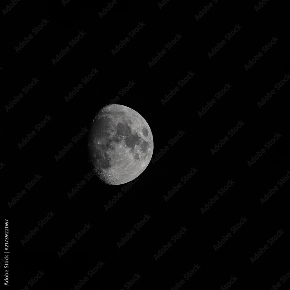 Fototapeta premium The moon before the full moon in the dark black sky