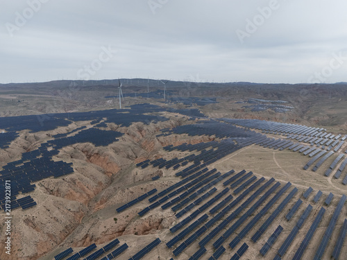 Obraz na płótnie solar power plant and wind turbines on barren hillside