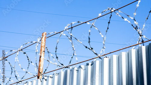 Quadro su tela Razor wire installed above a metal security fence to prevent unauthorized access