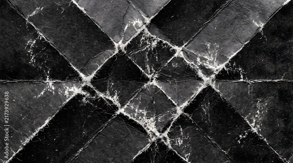 Obraz premium Dramatic dark abstract background featuring a deeply distressed black quilted texture, highlighting stark white frayed edges and a worn, aged textile pattern, ideal for grunge and modern design.