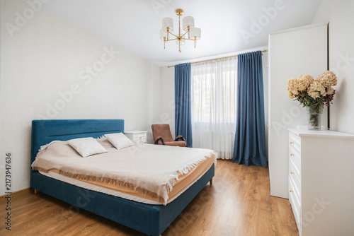 Foto Blue upholstered double bed and wooden floor in bedroom