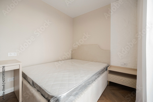 Obraz na plátně Unmade double bed with mattress in neutral bedroom interior
