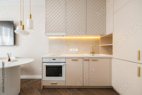 Bild auf Leinwand Beige kitchen cabinetry with latticed upper doors and brass hardware
