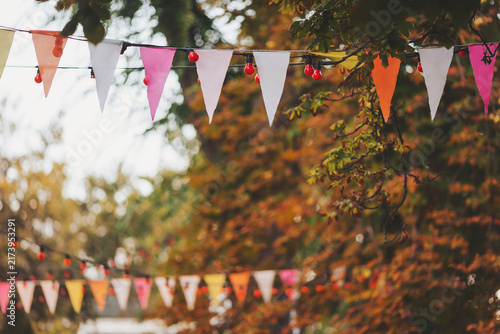 Colorful banners fluttering in the gentle breeze of an autumn festival celebrating community and warmth